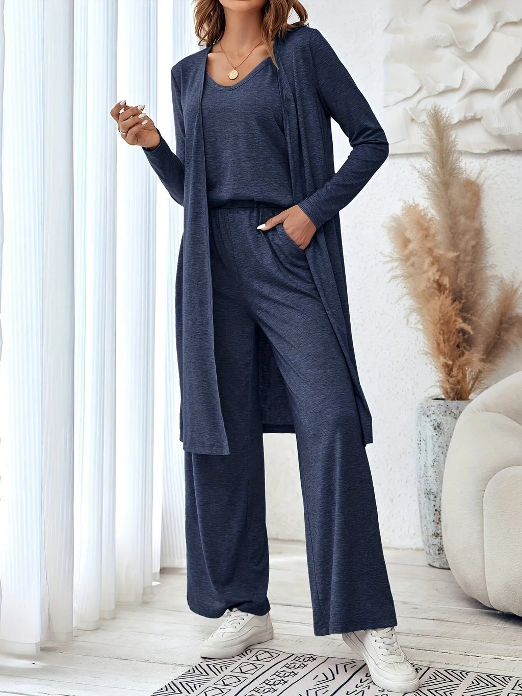 Blue women's three-piece co-ord suit with jumper top, long cardigan, and trousers with suspenders.