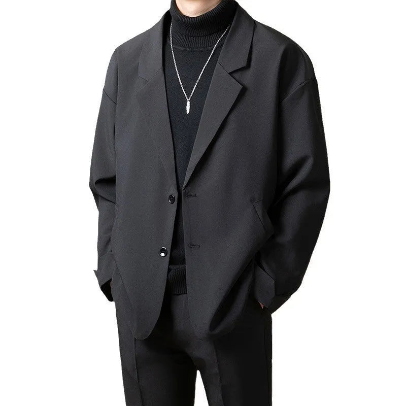 Man wearing a loose fit apricot coloured suit jacket with long sleeves.