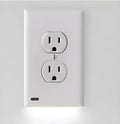 White plug-in socket induction LED night light installed in a wall outlet