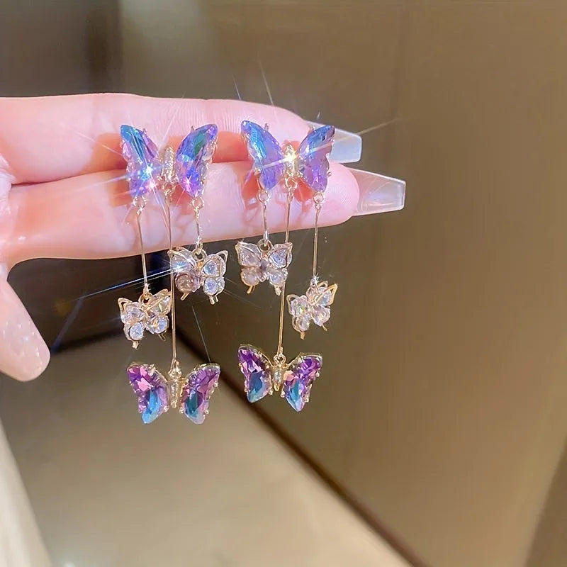 Blue purple butterfly earrings with silver needle crystal flowers and tassel detailing on alloy base