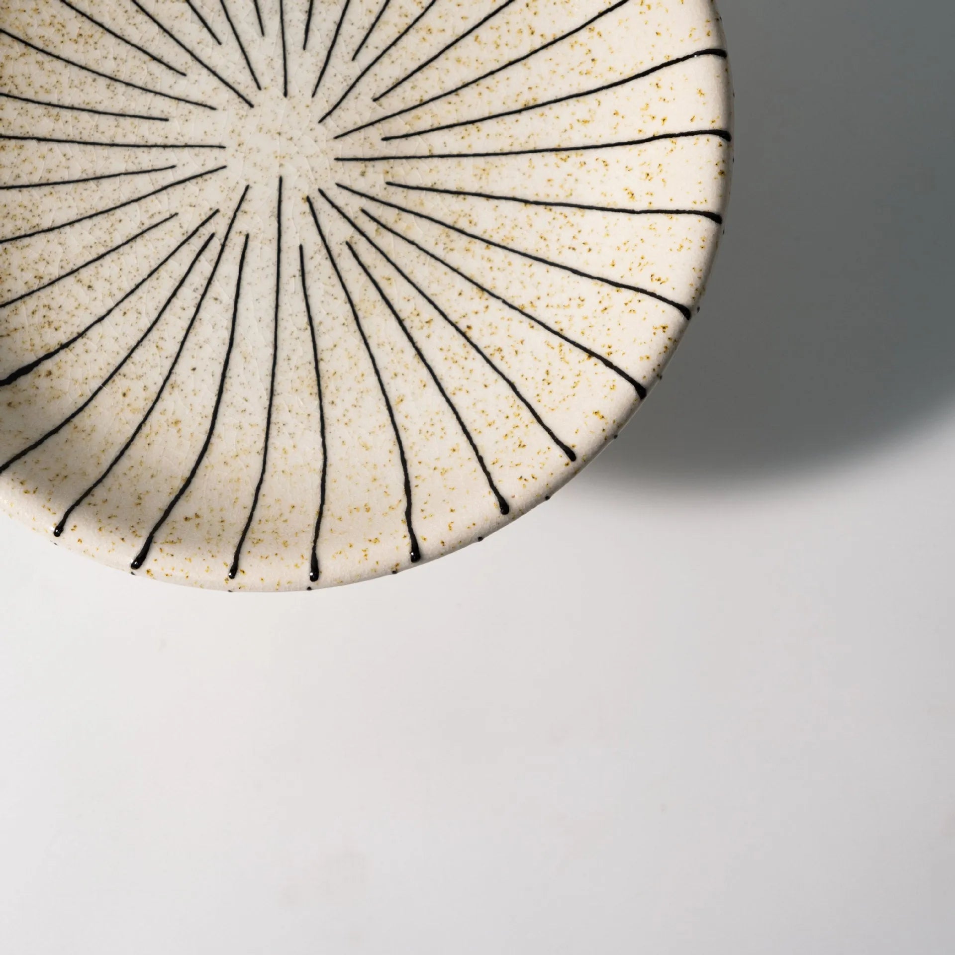 Black and white striped plastic resin fruit plate on a wooden surface.