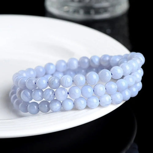 Blue agate bracelet with scattered multi-circle stripes and Ruyi design on wrist.