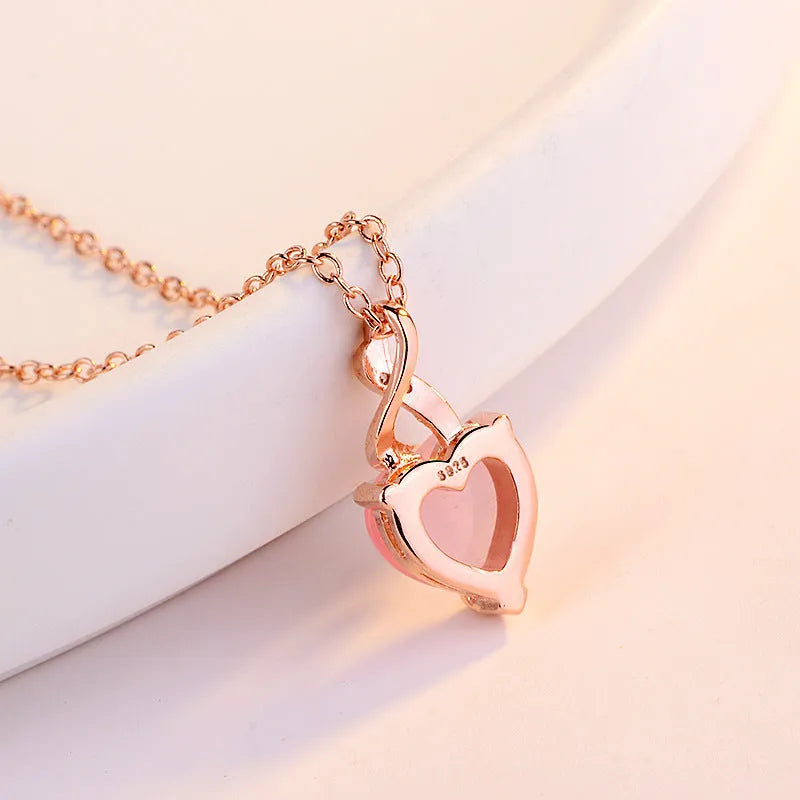 Women's necklace with heart-shaped pink crystal pendant on rose gold cross chain