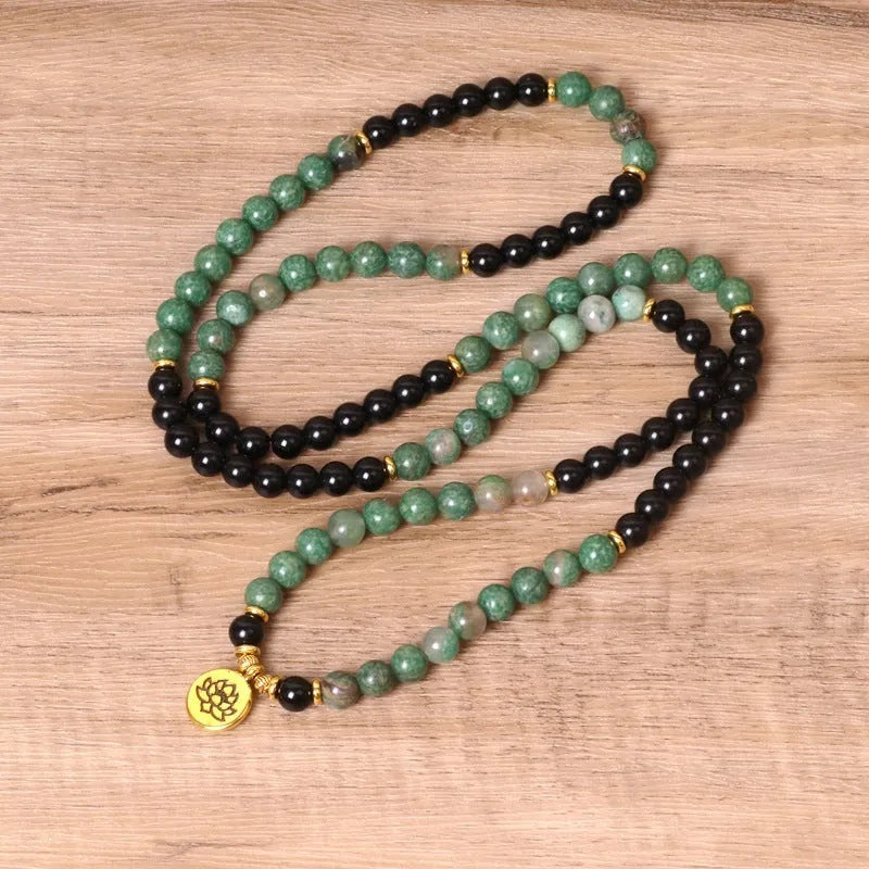 Green and black elastic beaded long bracelet with alloy construction shown on wrist