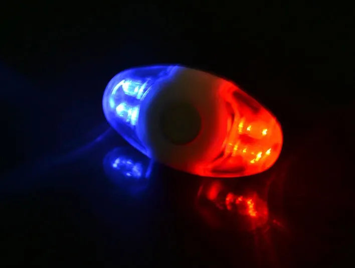 Red and blue LED tail light with adjustable mounting base on a dark background.