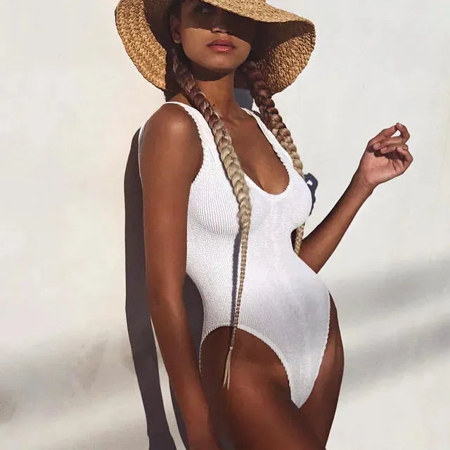 Women's solid colour one-piece swimsuit in seersucker bubble cloth fabric, showing backless and sleeveless design.