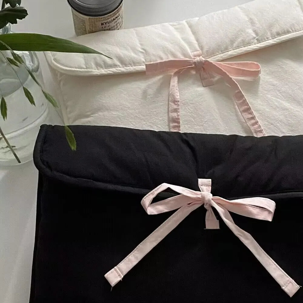 Women's black and white quilted laptop bag with bow detail and striped pattern