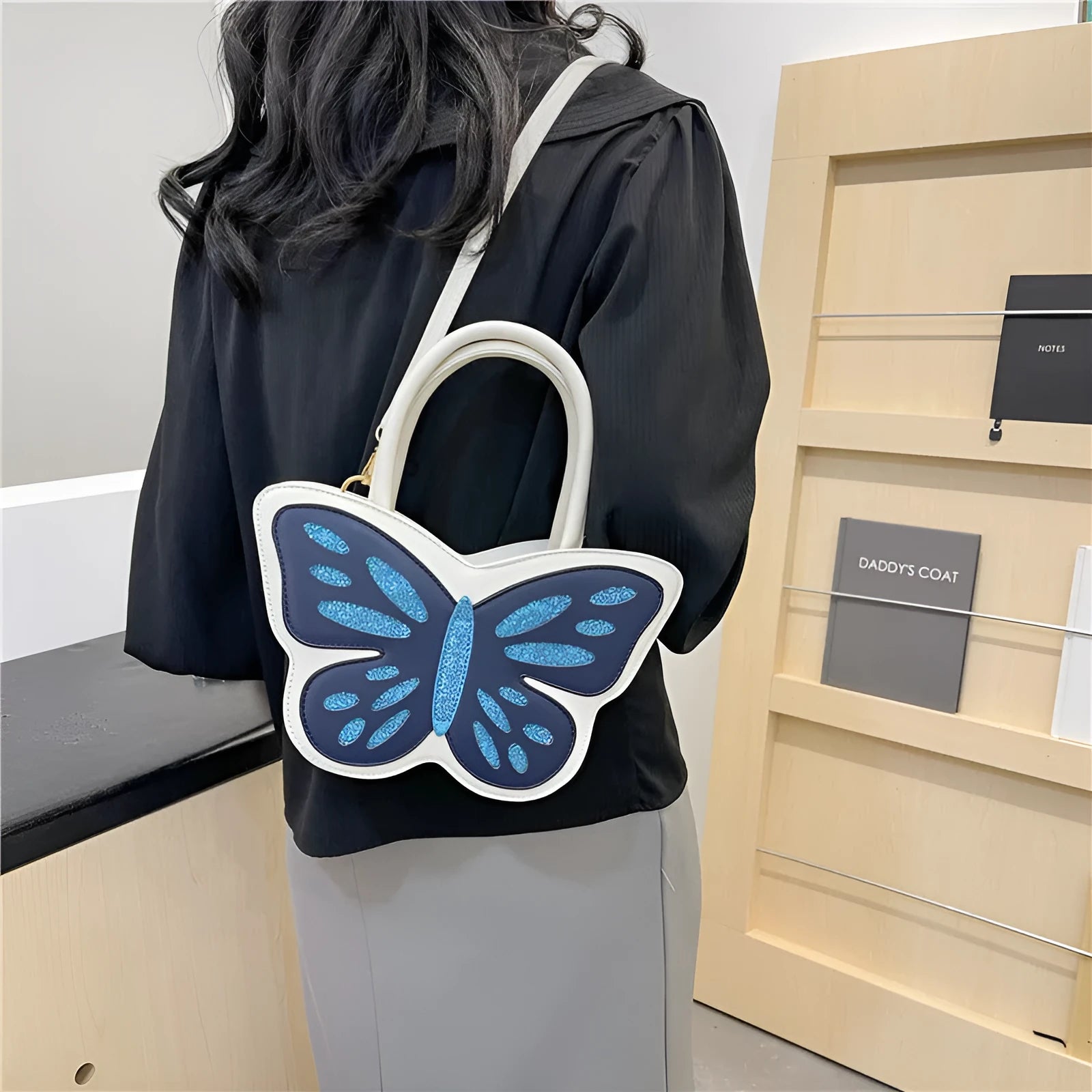 Small square white PU crossbody bag with contrast colour detailing on a model.