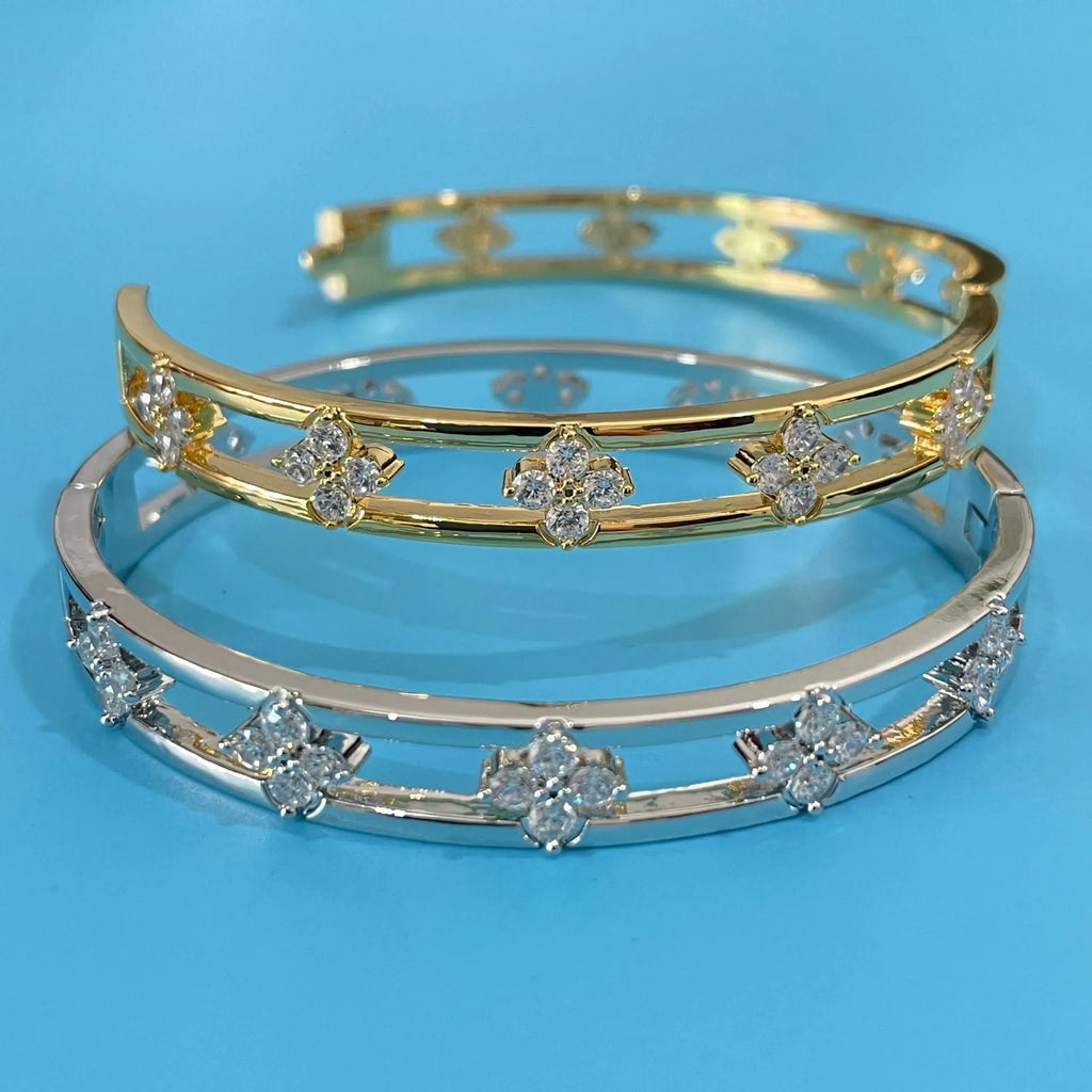 Gold and silver women's bracelets with hollow design and four-leaf clover zircon charms.