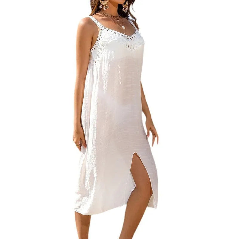 White crochet suspender beach dress with thigh slit on a hanger.