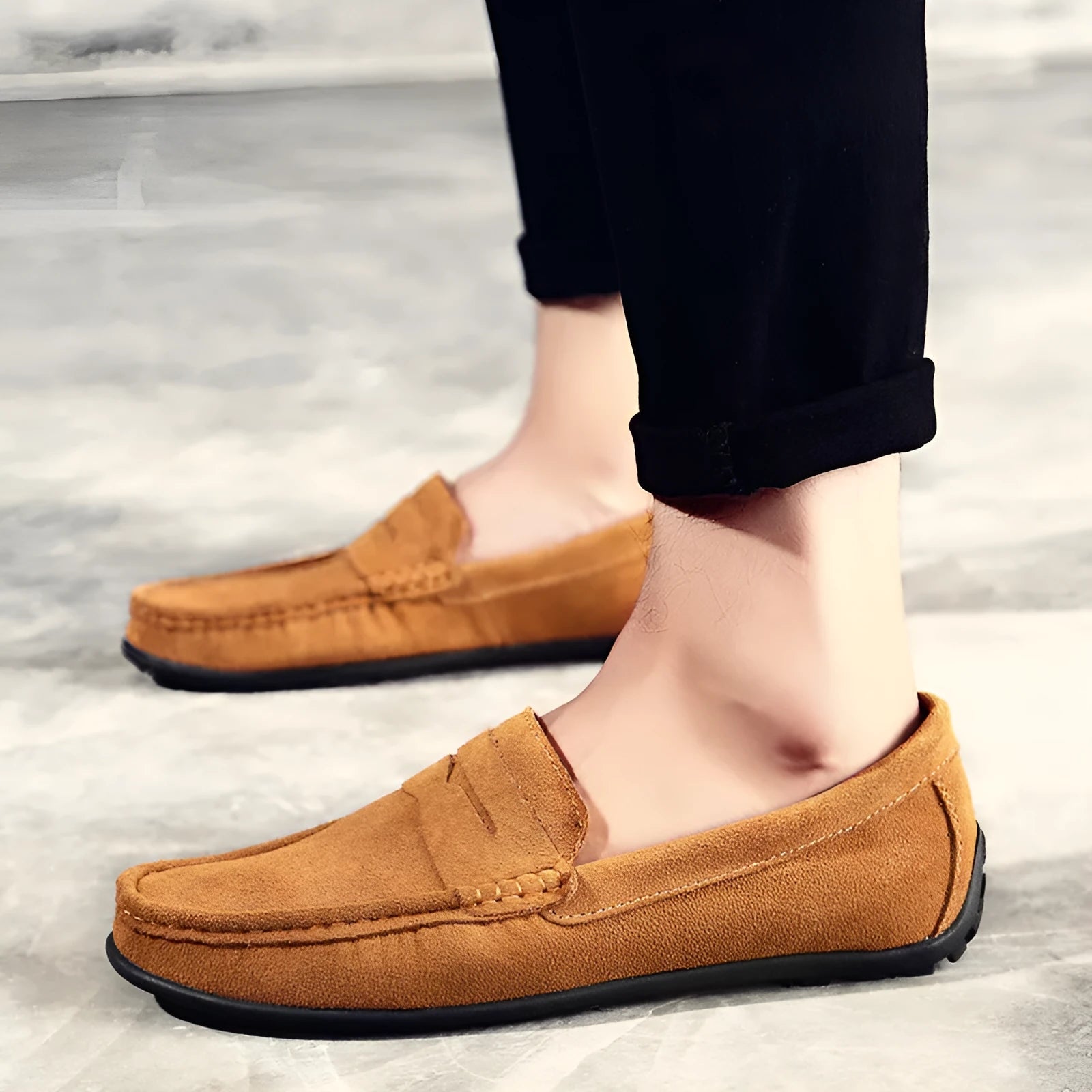 Men's suede leather Gommino loafers in black on a flat rubber sole, showing round toe and sewing line detail.