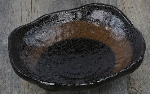 Creative Japanese ceramic sashimi bowl with irregular shape and floral decoration on table
