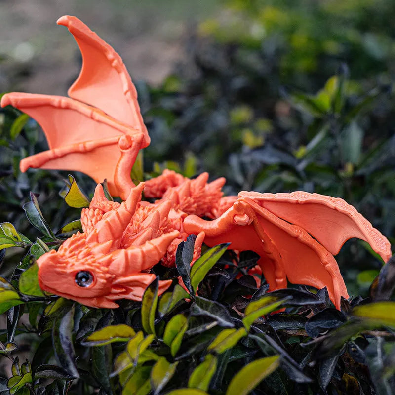 3D printed red and gold flying dragon wings decoration toy on a white background.