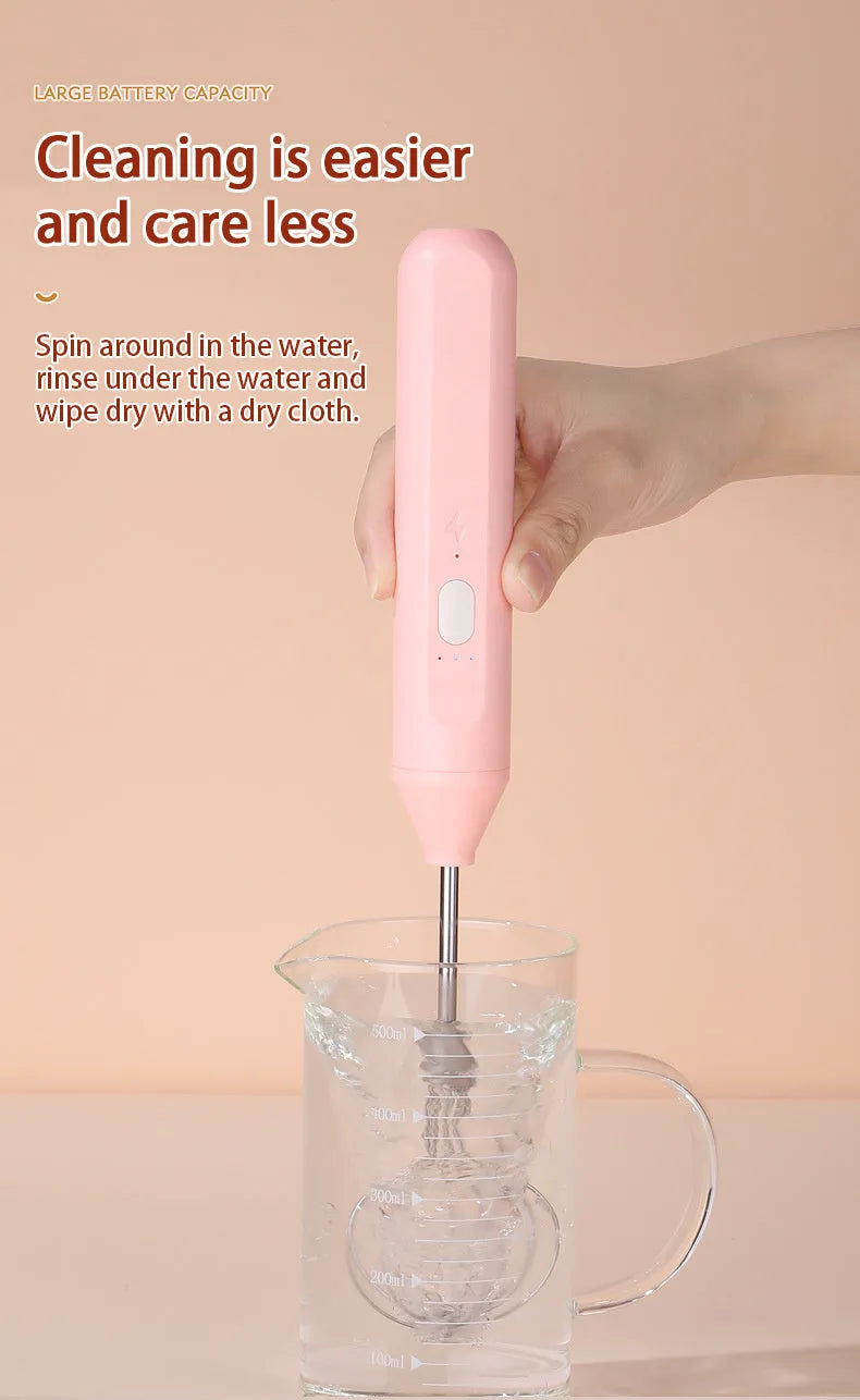 Hand-held wireless electric whisk in black and pink, with straight handle and stainless steel whisk attachment