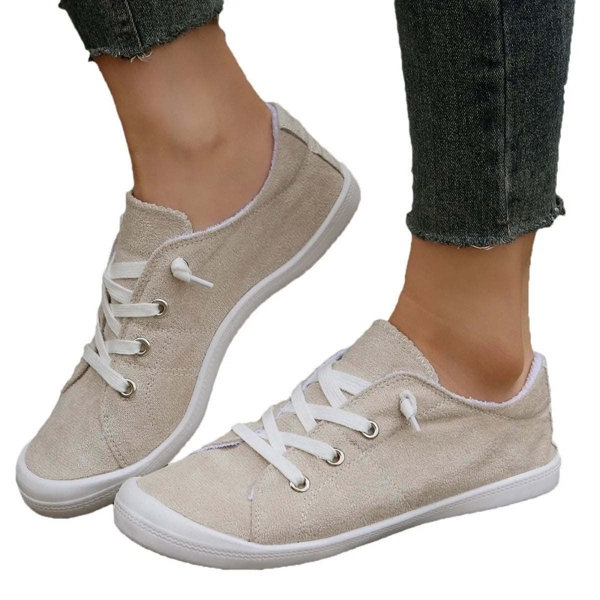 Creamy white low-top women's casual sneakers with a fabric upper and rubber sole.