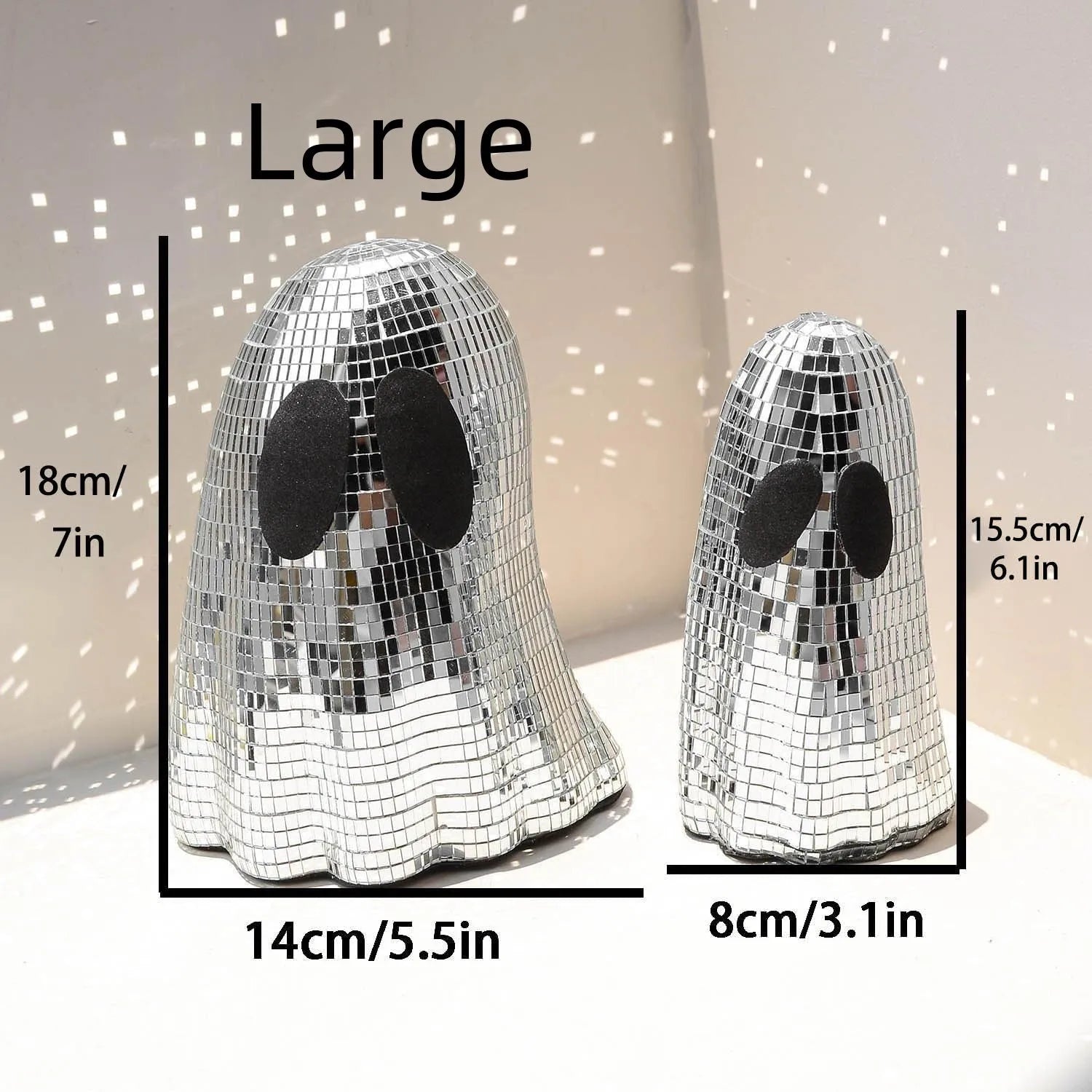 Silver glass Halloween ghost ornament with mosaic inlaid surface on a desktop.