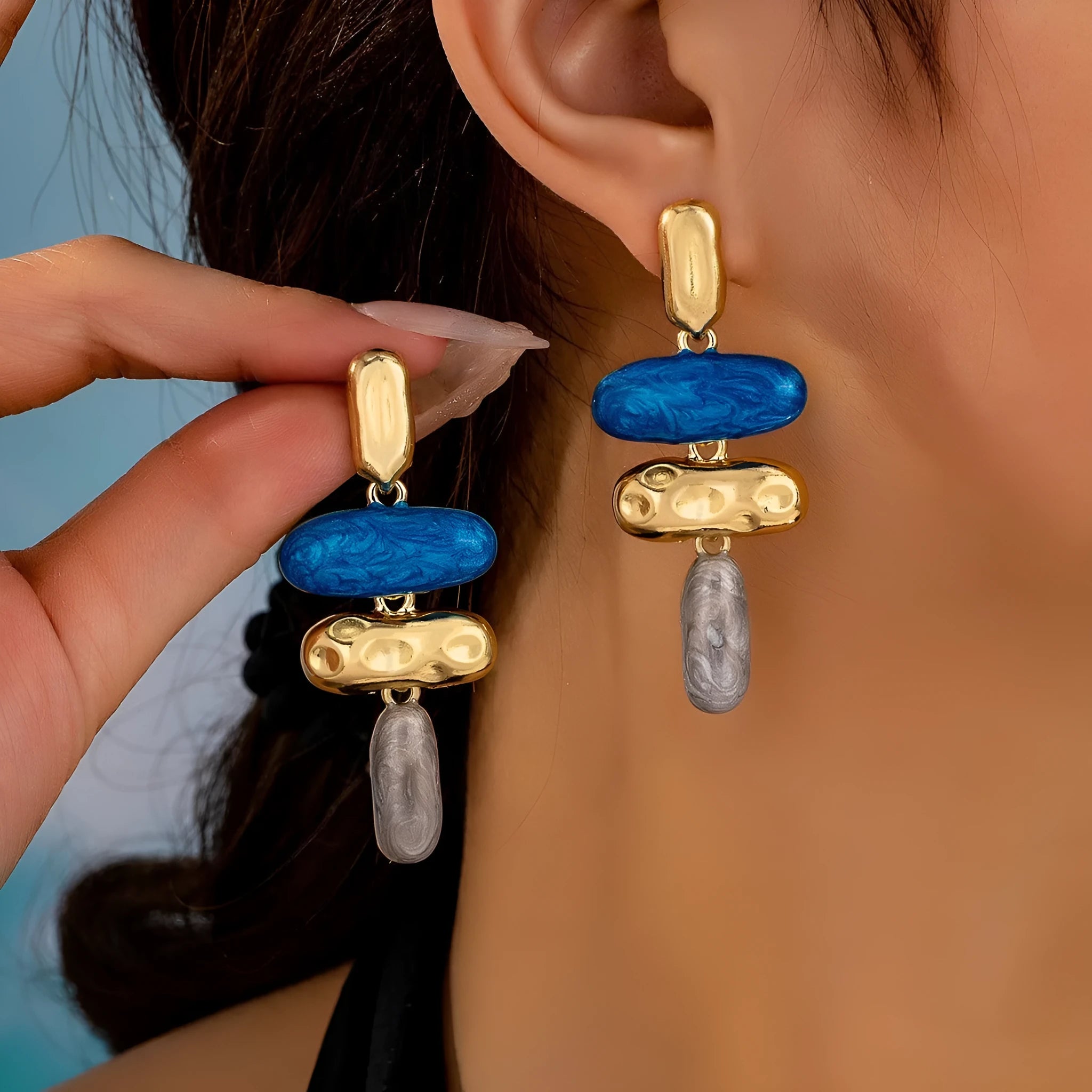 A pair of simple geometric stud earrings with a multicolour electroplated finish on a zinc alloy base.