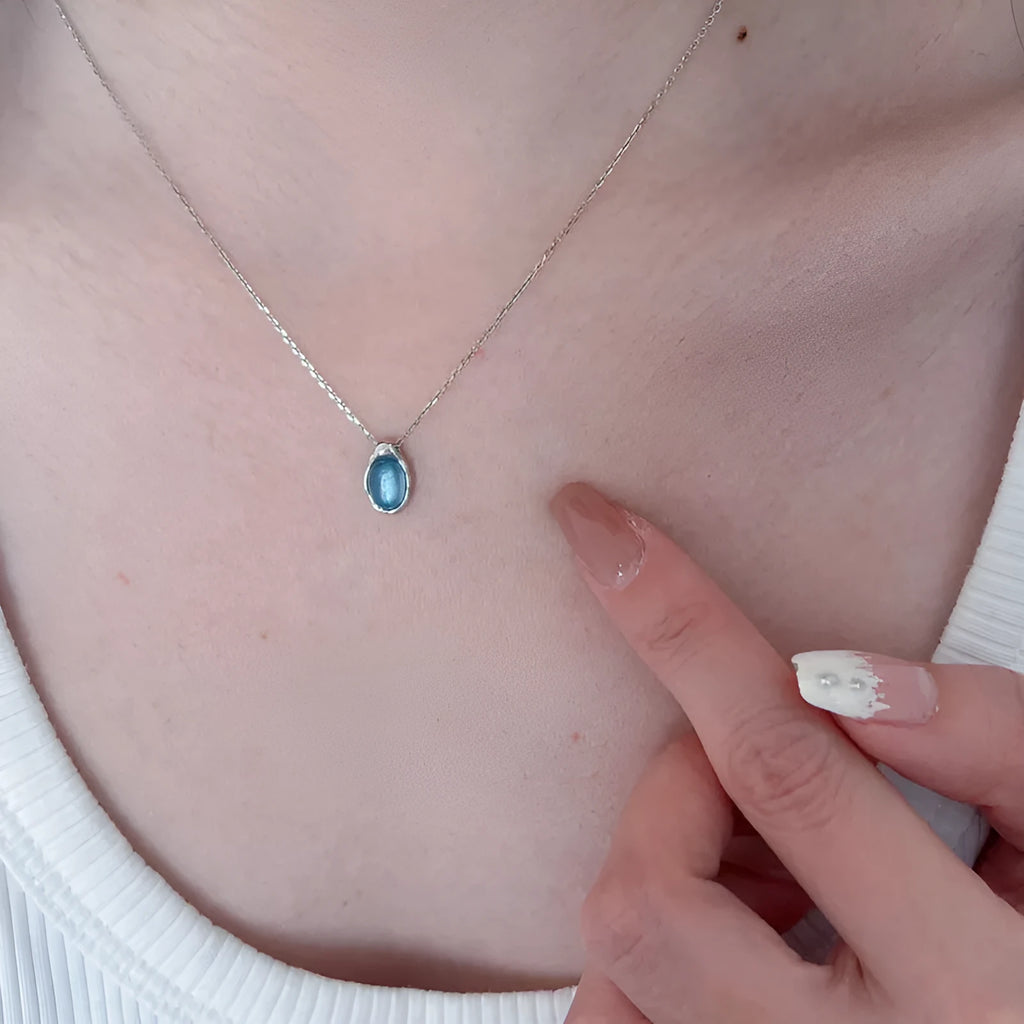 Navy blue water drop necklace with geometric design on adjustable cross chain