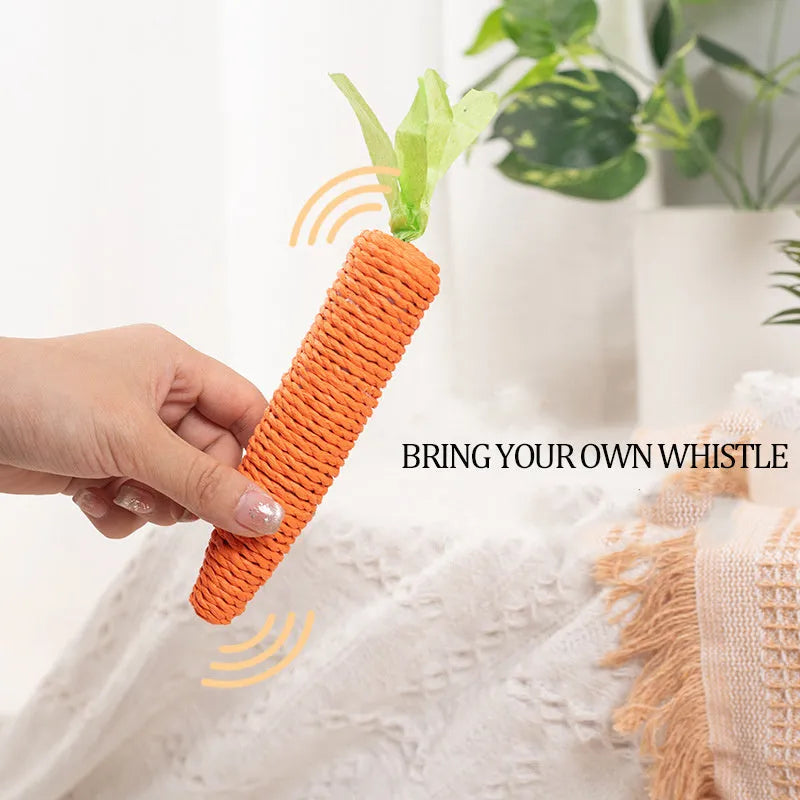 Assortment of colourful interactive cat toys including plastic carrots, ringing stones, fabric sticks, paper toys, and chewing sticks.