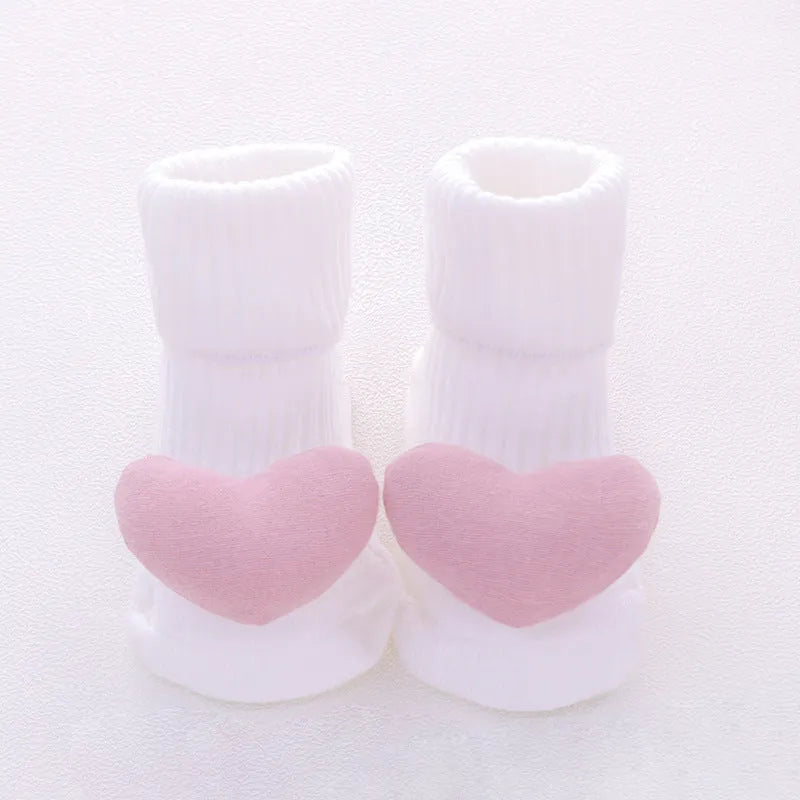 Cotton baby floor socks with non-slip soles in a pink bow print design.