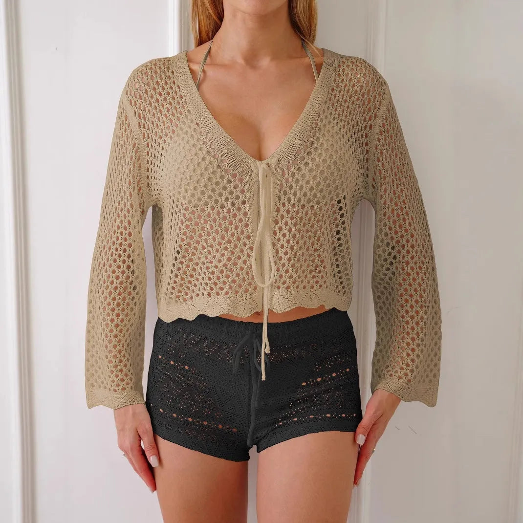 Women's apricot hollow knit cardigan blouse with bell sleeves laid flat.