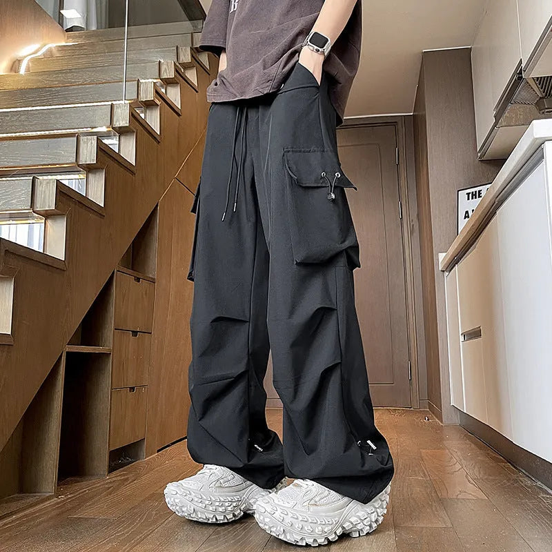 Black waterproof plus size loose straight-leg trousers with a drawstring waist on a hanger.