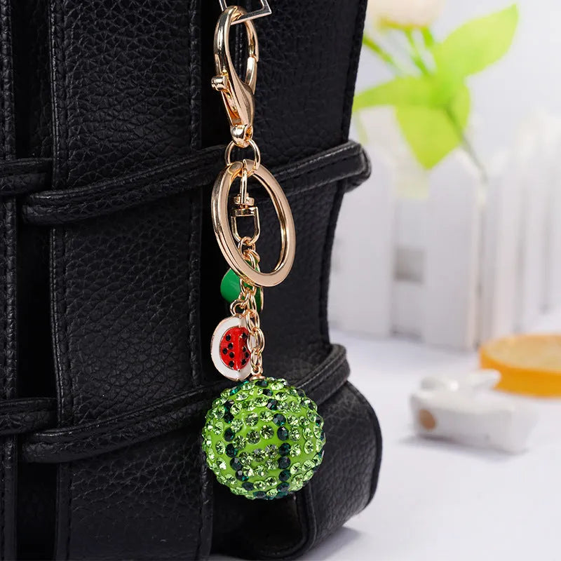 Green watermelon-shaped zinc alloy keychain measuring 12 cm in length
