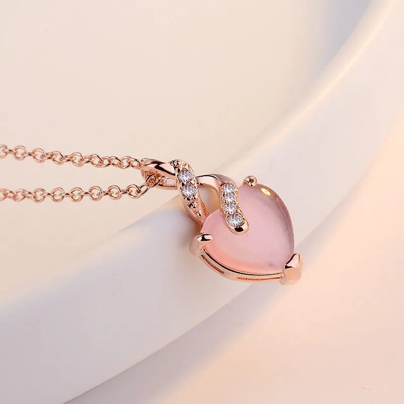 Women's necklace with heart-shaped pink crystal pendant on rose gold cross chain