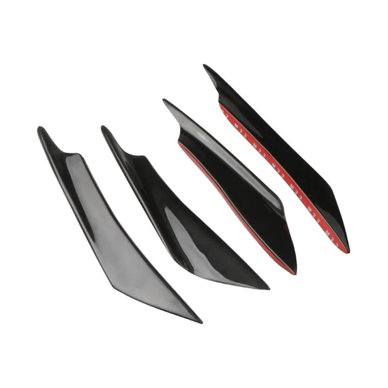 Set of four carbon fibre pattern bumper blade spoilers for car modification on a black background.