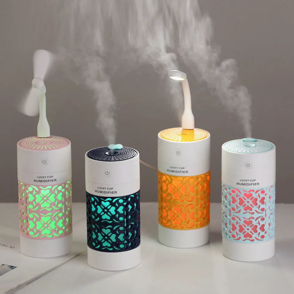 Lucky desktop humidifier 250ml USB powered in black with blue water bottle showing mist output on office desk