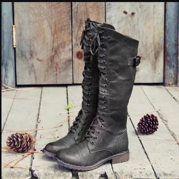 Women's black chunky heel high leg boots with a round toe and low block heel on a white background.