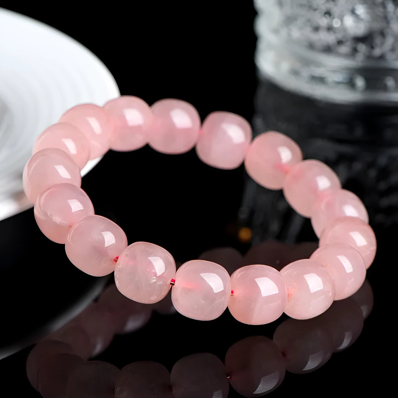 Pink natural crystal barrel bead bracelet with geometric shape on wrist