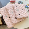White nylon laptop bag with embroidered rhombus pattern and fabric bow, shown alongside black, light blue, and light pink colour options.