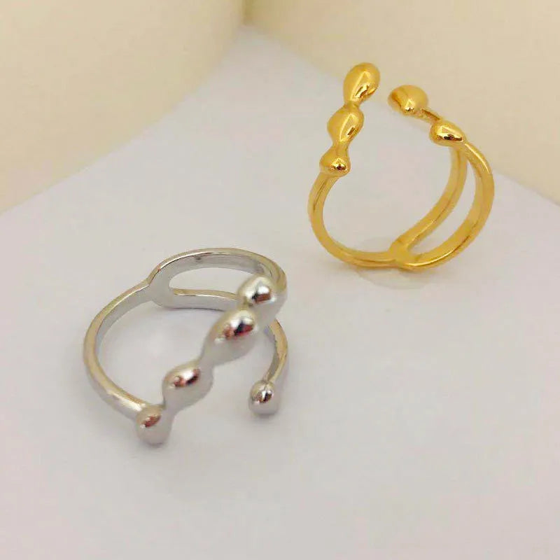 Brass opening ring in gold or silver finish with spherical design details.