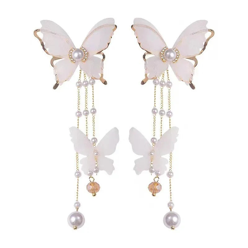 White butterfly earrings with lace design, pearl accents, rhinestones, and tassel on electroplated copper alloy