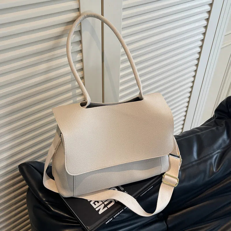 A brown PU tote bag with double shoulder straps and visible sewing thread detail.