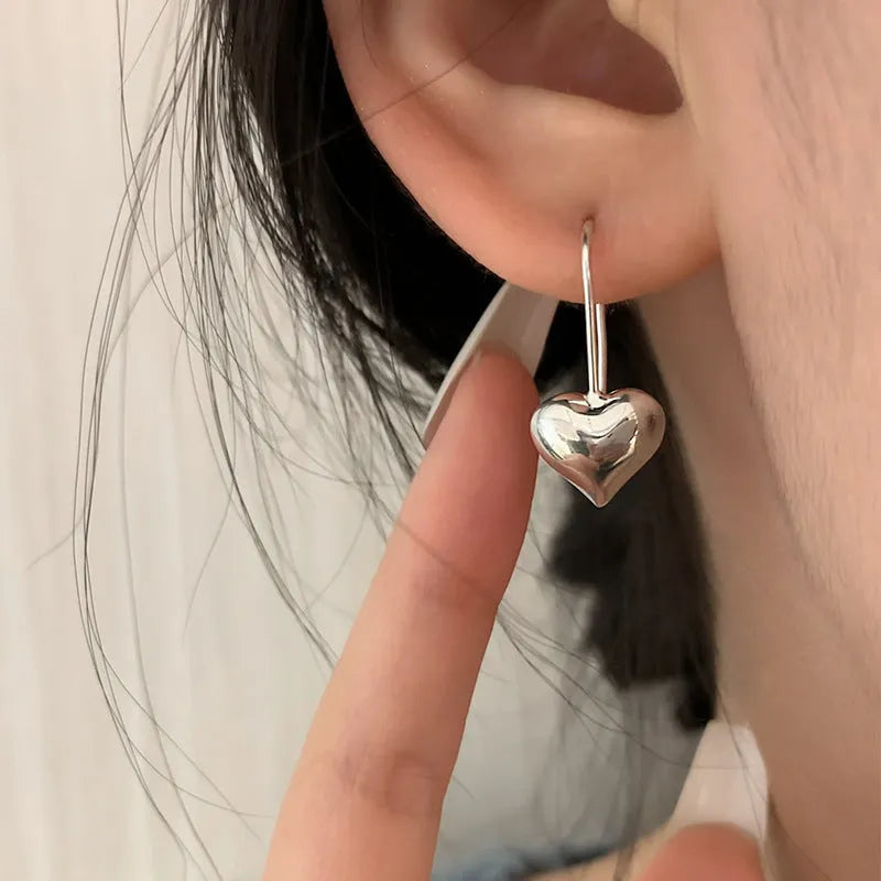 Korean style silver-coloured heart earrings with three-dimensional glossy finish and matching heart-shaped ear hooks