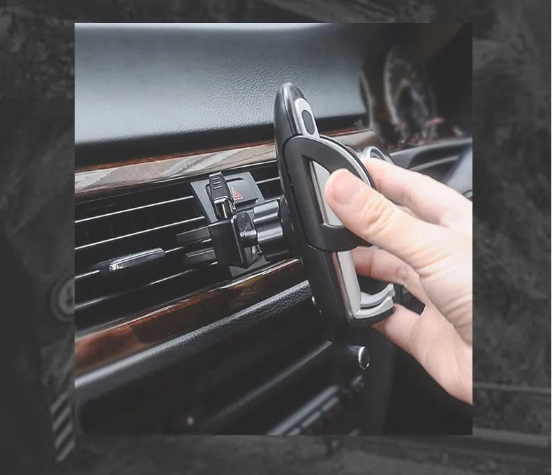 Black plastic mobile phone holder mounted on a car air conditioning vent
