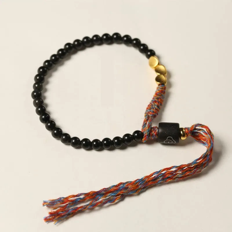 Hand-woven obsidian carrying strap bracelet showing textured weave and 4mm width