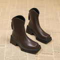 Women's black platform Martin ankle boots with a square toe and back zipper on a white background