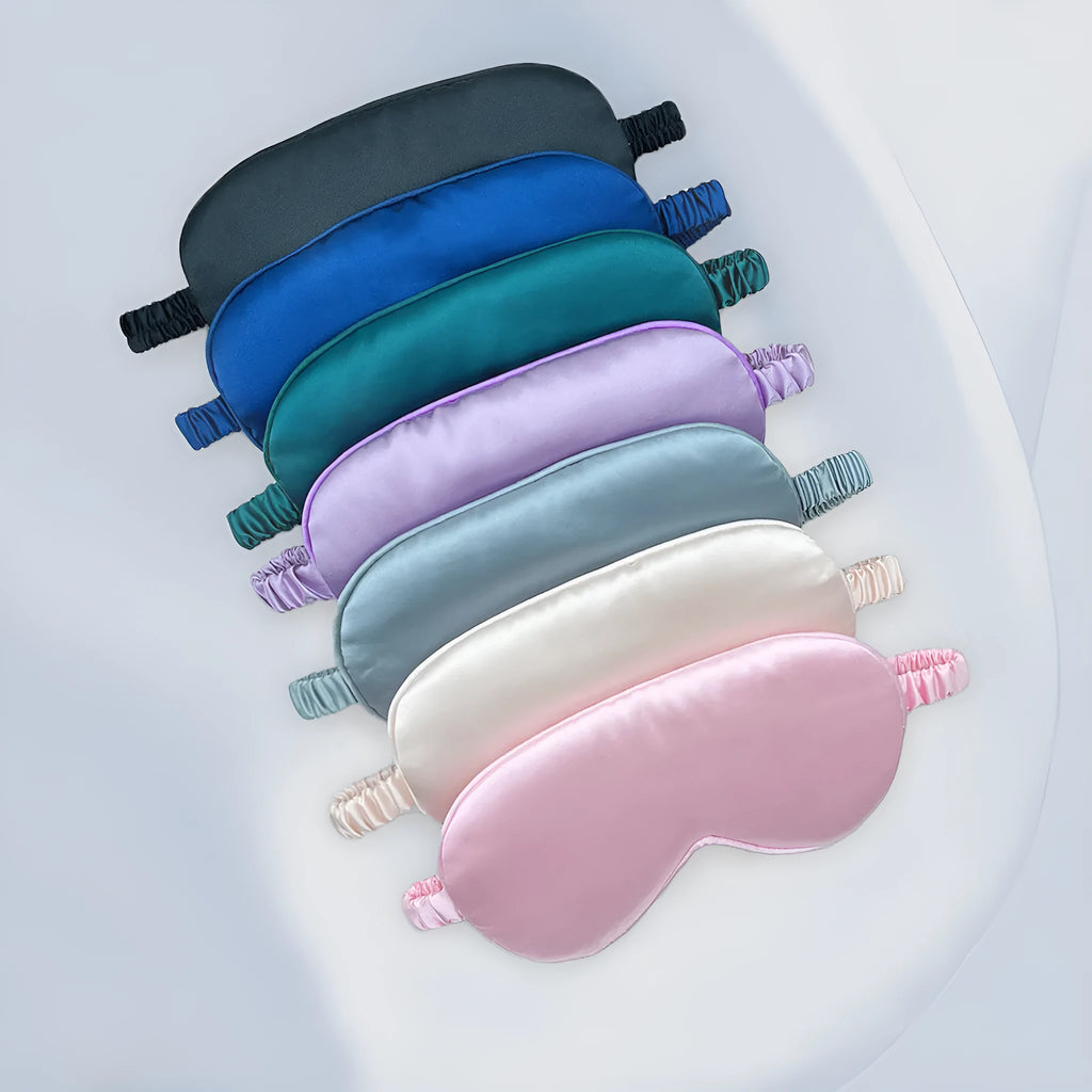Double-sided silk-like sleep mask in rayon satin, shown in multiple colour options on a white background.