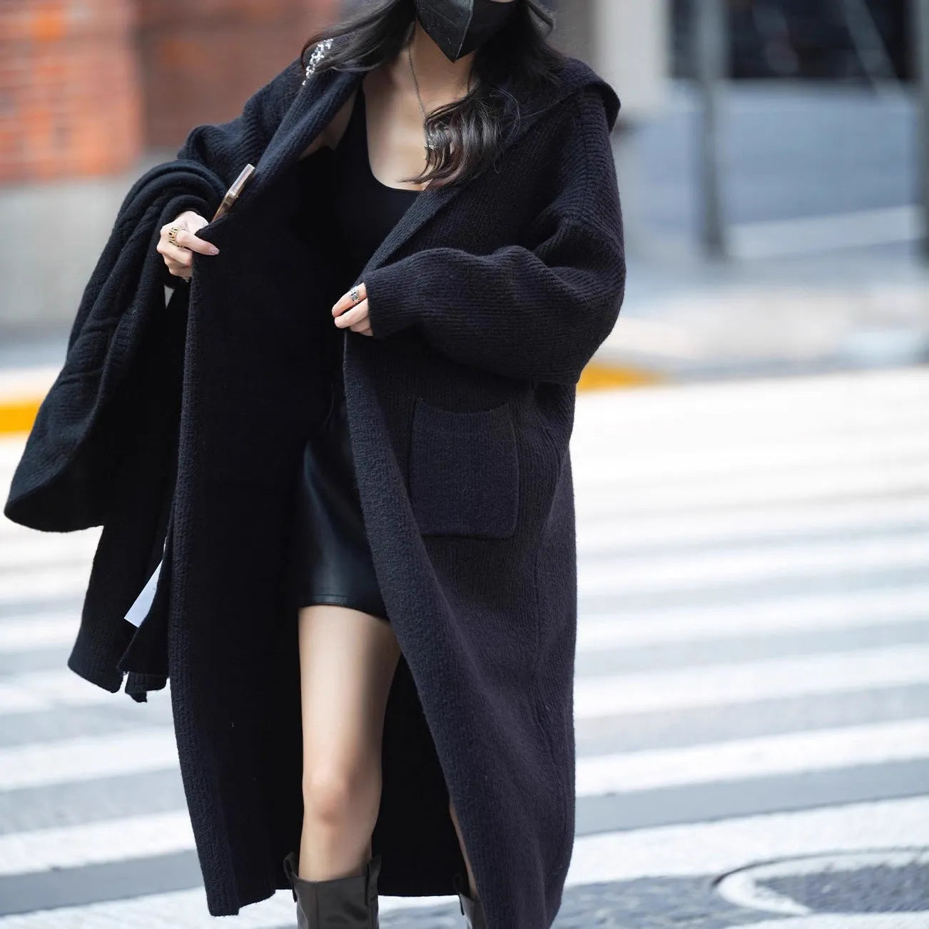 Long grey knitted hooded cardigan trench coat with loose fit on a model.