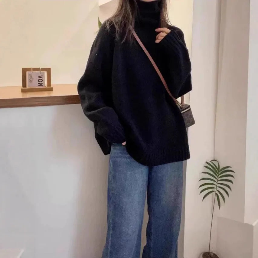 Women's loose grey turtleneck sweater with thick curling pile collar, worn in a casual setting.