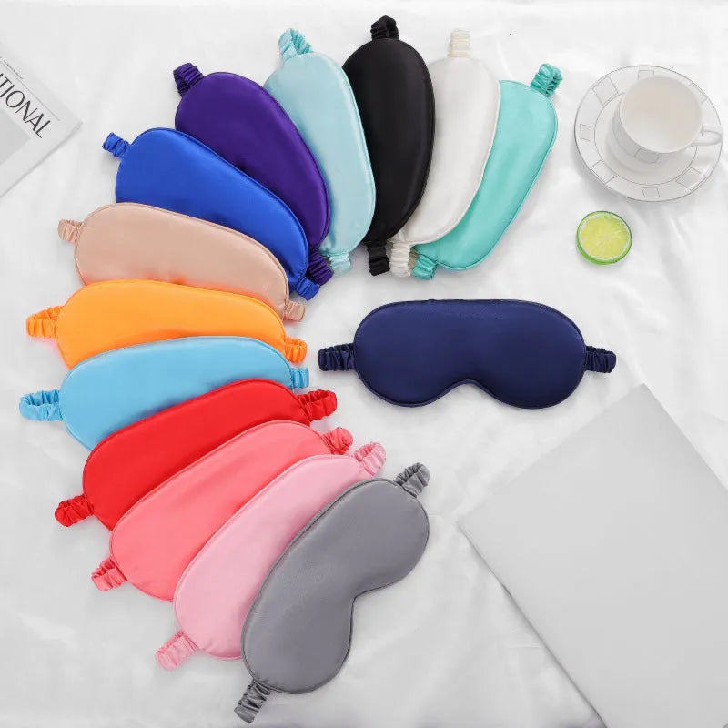 Double-sided silk-like sleep mask in rayon satin, shown in multiple colour options on a white background.