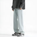 Men's light wash blue straight leg jeans with button fly on a hanger.