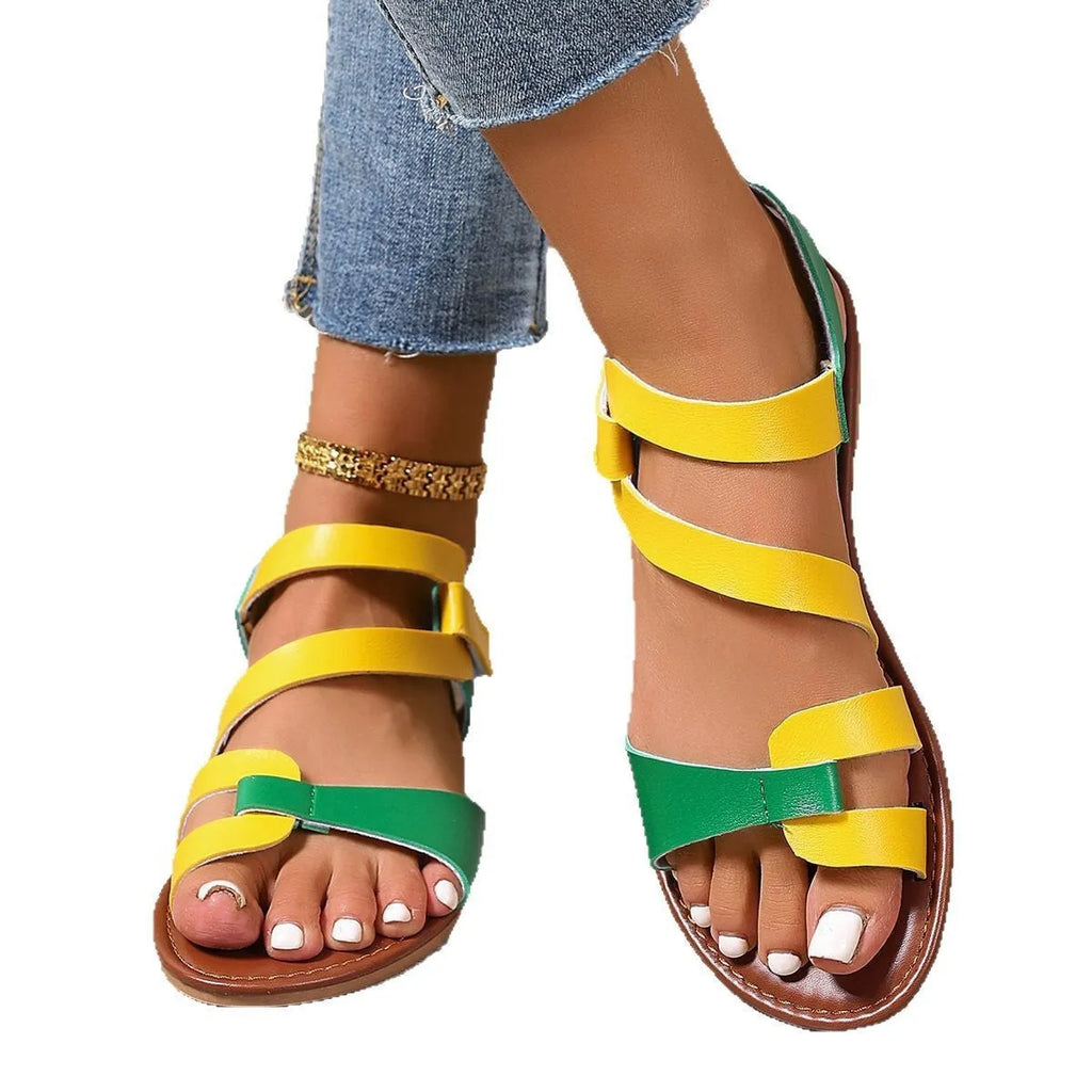Women's brown flat sandals with Velcro fastening and rubber sole on a white background.