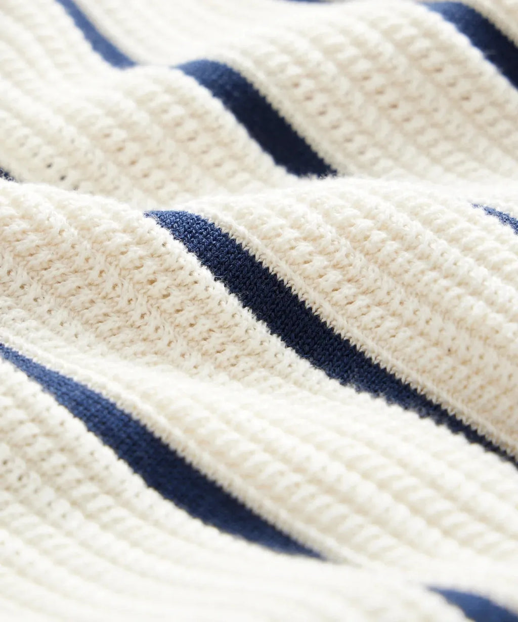 Men's white short sleeve knitted top with lapel neckline and asymmetrical British style design