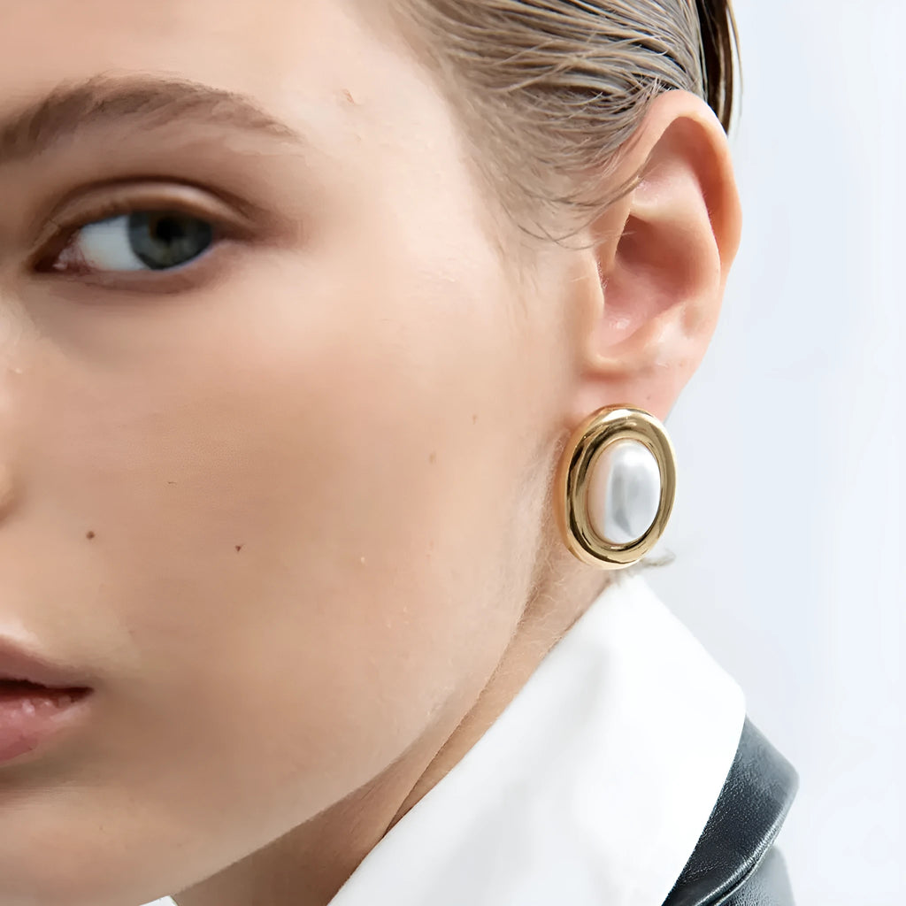 A pair of stainless steel stud earrings with a vintage-style faux pearl centre in colour JDE0305051.