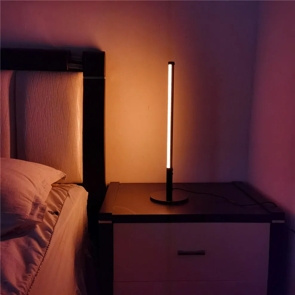 Tall, cylindrical black aluminium alloy retro atmosphere lamp on a table.
