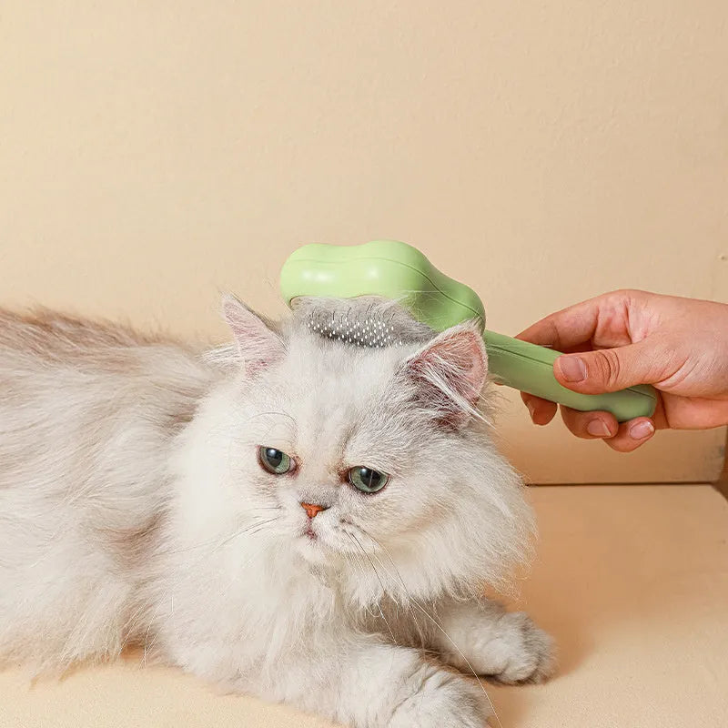 Self-cleaning stainless steel cat comb with green handle, showing 4-row needle design